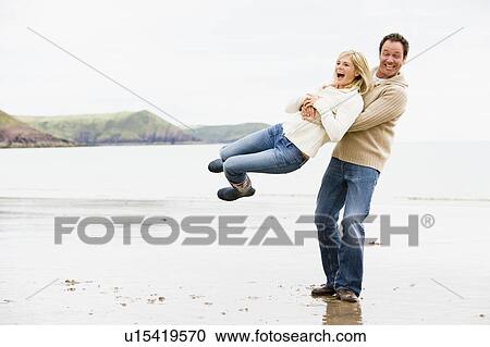 Couple playing on beach smiling View Large Photo Image Stock Image - Couple playing on beach smiling. Fotosearch