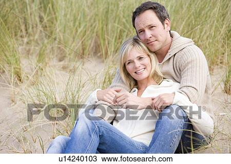 Couple sitting on beach smiling View Large Photo Image Stock Image - Couple sitting on beach smiling. Fotosearch