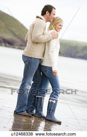 Couple standing on beach smiling View Large Photo Image Stock Photo - Couple standing on beach smiling. Fotosearch
