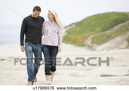 Couple walking at beach smiling View Large Photo Image Stock Photo - Couple walking at beach smiling. Fotosearch