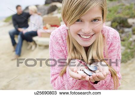 Family at beach with picnic smiling focus on girl with seashells View Large Photo Image Stock Image - Family at beach with picnic smiling focus on girl with seashells. Fotosearch
