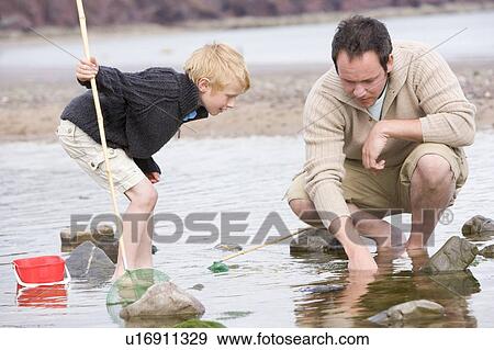 Father and son at beach fishing View Large Photo Image Stock Photo - Father and son at beach fishing. Fotosearch