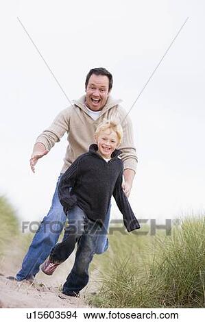 Father and son running on beach smiling View Large Photo Image Picture - Father and son running on beach smiling. Fotosearch
