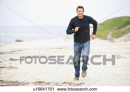 Man running at beach smiling View Large Photo Image Stock Image - Man running at beach smiling. Fotosearch