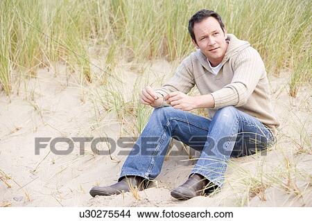 Man sitting on beach View Large Photo Image Picture - Man sitting on beach. Fotosearch