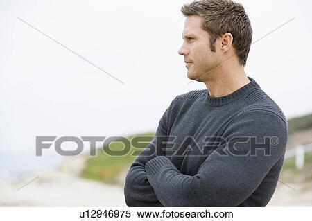 Stock Photography - Man standing at beach. Fotosearch