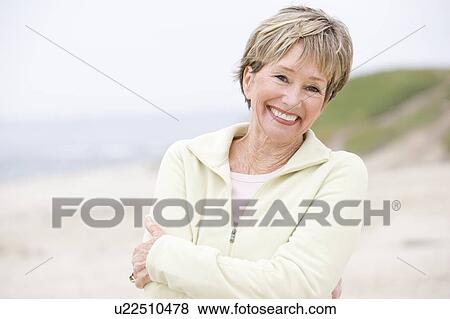 Woman at the beach with arms crossed smiling View Large Photo Image Stock Photo - Woman at the beach with arms crossed smiling. Fotosearch