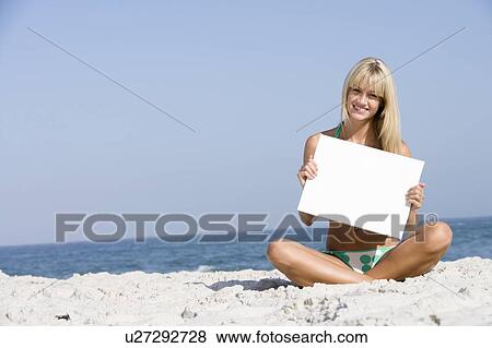 Woman holding a blank card on a beach View Large Photo Image Stock Photo - Woman holding a blank card on a beach. Fotosearch