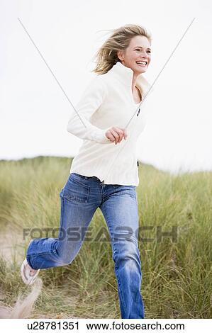 Woman running at beach smiling View Large Photo Image Stock Image - Woman running at beach smiling. Fotosearch