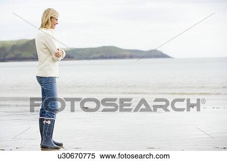 Woman standing on beach smiling View Large Photo Image Stock Photography - Woman standing on beach smiling. Fotosearch