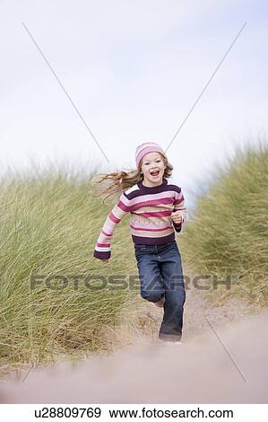Young girl running on beach smiling View Large Photo Image Stock Photo - Young girl running on beach smiling. Fotosearch