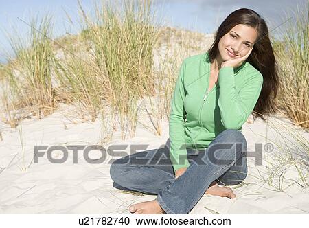 Stock Image - Young woman posing on a sand hill. Fotosearch