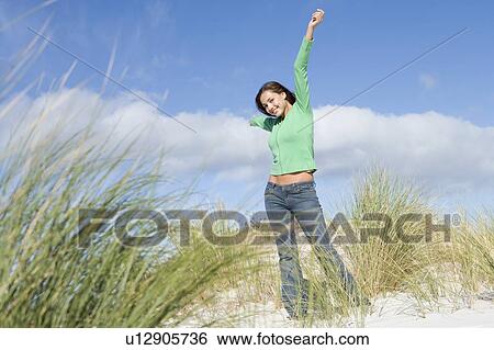 Young woman posing on a sand hill View Large Photo Image Stock Photograph - Young woman posing on a sand hill. Fotosearch