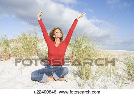 Stock Photograph - Young woman posing on a sand hill. Fotosearch
