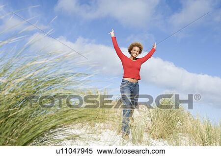 Young woman posing on a sand hill View Large Photo Image Stock Photography - Young woman posing on a sand hill. Fotosearch