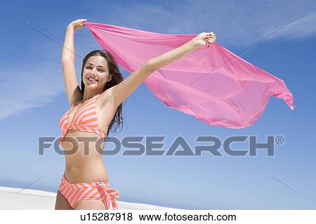 Young woman posing with a scarf on a beach View Large Photo Image Stock Photo - Young woman posing with a scarf on a beach. Fotosearch