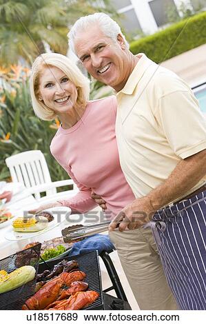 Stock Photo - Couple Cooking On A Barbeque. Fotosearch