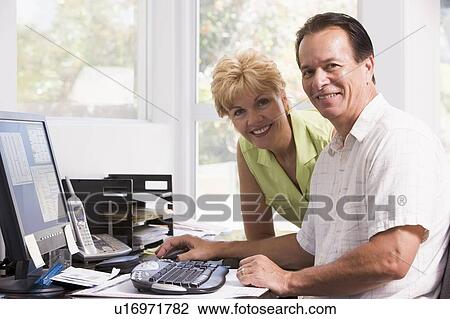 Couple in home office at computer smiling View Large Photo Image Stock Image - Couple in home office at computer smiling. Fotosearch