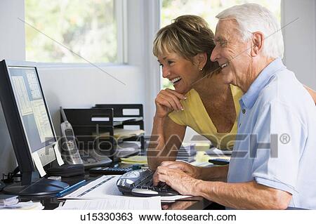 Couple in home office with computer and paperwork smiling View Large Photo Image Stock Image - Couple in home office with computer and paperwork smiling. Fotosearch