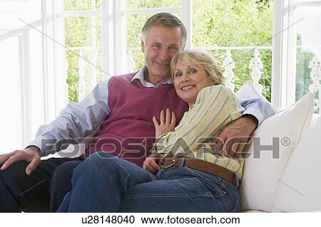 Couple in living room smiling View Large Photo Image Stock Image - Couple in living room smiling. Fotosearch