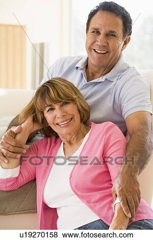Couple relaxing in living room and smiling View Large Photo Image Stock Photo - Couple relaxing in living room and smiling. Fotosearch