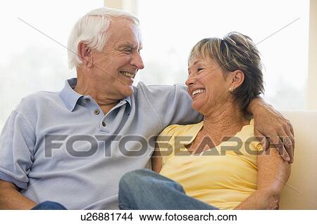 Picture - Couple relaxing in living room smiling. Fotosearch