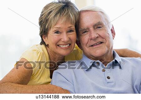 Couple relaxing in living room smiling View Large Photo Image Stock Photo - Couple relaxing in living room smiling. Fotosearch
