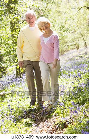Stock Photo - Couple walking outdoors smiling. Fotosearch