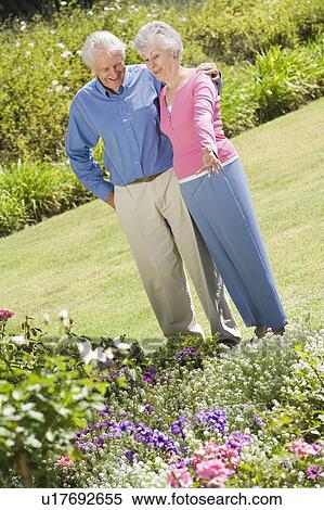 Stock Photography - Senior couple in a flower garden. Fotosearch