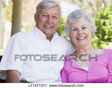 Stock Image - Senior couple sitting outdoors. Fotosearch