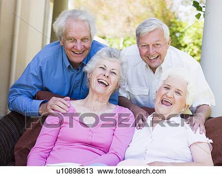 Stock Image - Two senior women sitting outdoors on a chair. Fotosearch