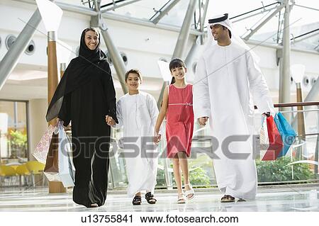 Family walking in mall holding hands and smiling (selective focus) View Large Photo Image Stock Image - Family walking in mall holding hands and smiling (selective focus). Fotosearch