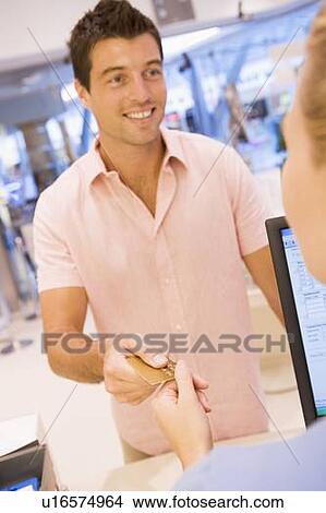 Man paying for purchases with credit card View Large Photo Image Picture - Man paying for purchases with credit card. Fotosearch