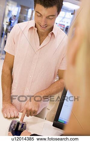 Stock Photography - Man paying for purchases with credit card. Fotosearch