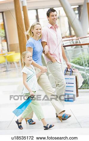 Stock Image - Mother and father with young daughter at a shopping mall. Fotosearch