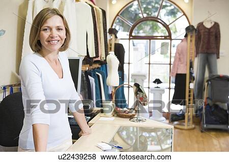 Stock Photo - Woman at clothing store smiling. Fotosearch