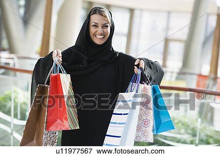 Woman standing in mall smiling (selective focus) View Large Photo Image Stock Photo - Woman standing in mall smiling (selective focus). Fotosearch