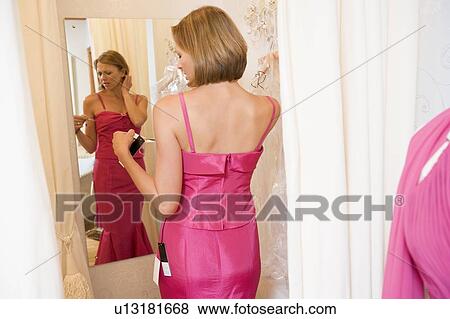 Woman trying on dresses and frowning View Large Photo Image Stock Photo - Woman trying on dresses and frowning. Fotosearch