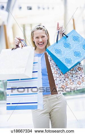 Woman with shopping bags at a shopping mall View Large Photo Image Picture - Woman with shopping bags at a shopping mall. Fotosearch