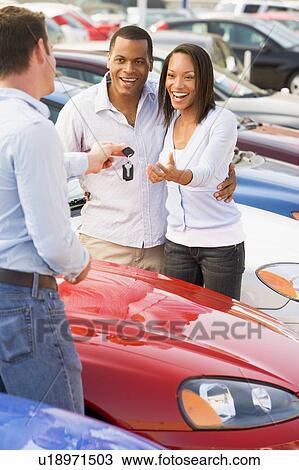 Stock Image - Young couple shopping for a new car. Fotosearch