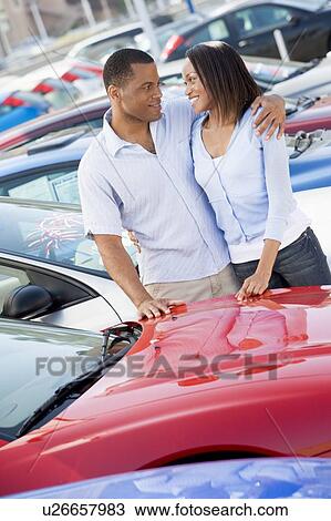 Stock Image - Young couple shopping for a new car. Fotosearch