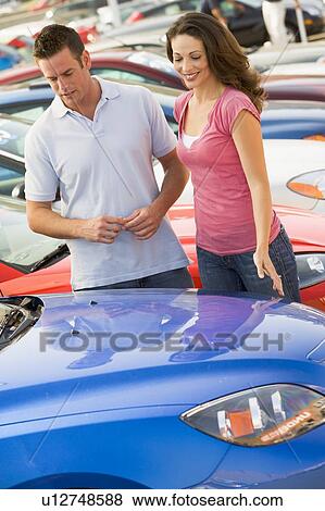 Young couple shopping for a new car View Large Photo Image Stock Photo - Young couple shopping for a new car. Fotosearch