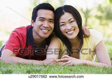 Couple lying outdoors smiling View Large Photo Image Stock Image - Couple lying outdoors smiling. Fotosearch