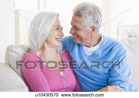 Couple relaxing in living room and smiling View Large Photo Image Stock Image - Couple relaxing in living room and smiling. Fotosearch