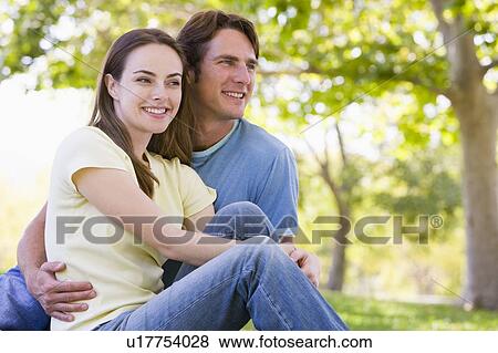 Couple sitting outdoors smiling View Large Photo Image Stock Photo - Couple sitting outdoors smiling. Fotosearch