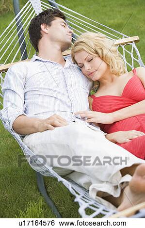 Stock Photograph - Couple sleeping in hammock. Fotosearch