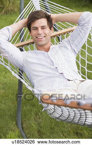 Man relaxing in hammock smiling View Large Photo Image Stock Photograph - Man relaxing in hammock smiling. Fotosearch
