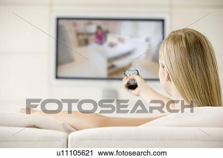 Woman in living room watching television View Large Photo Image Stock Image - Woman in living room watching television. Fotosearch