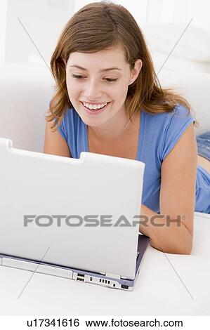 Woman in living room with laptop smiling View Large Photo Image Stock Photograph - Woman in living room with laptop smiling. Fotosearch