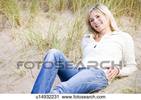 Woman lying on beach smiling View Large Photo Image Stock Image - Woman lying on beach smiling. Fotosearch